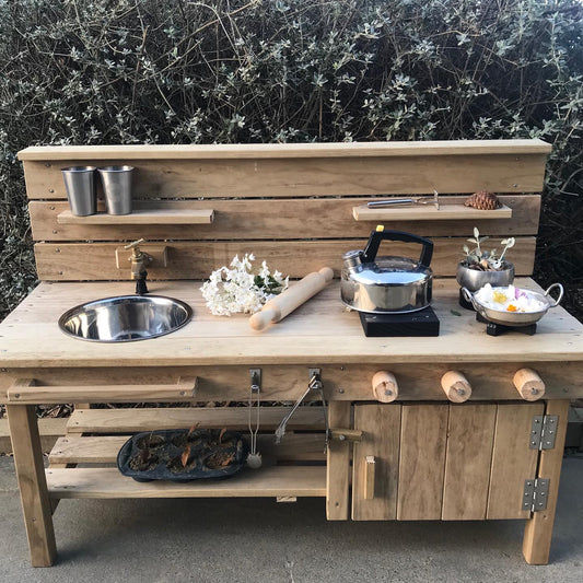 Outdoor wood mud kitchen for children. Opening oven door, turning knobs and elements. Working outdoor tap and removable sink bowl. 